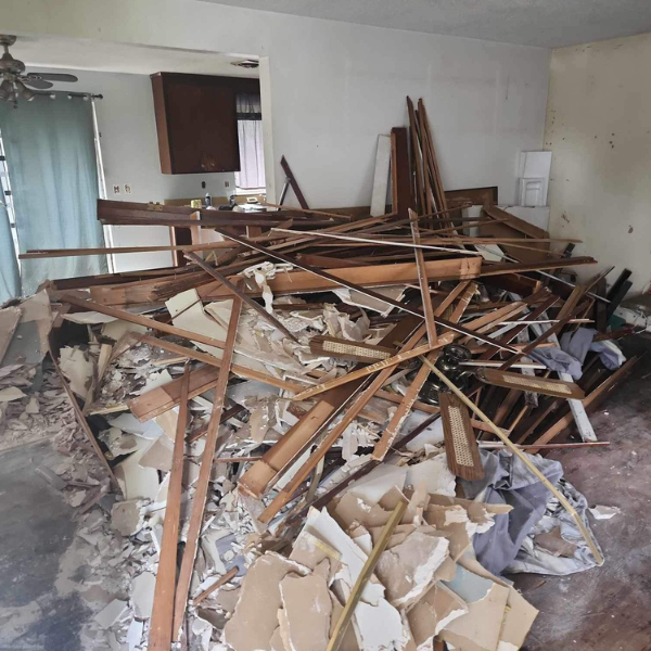 Interior filled with demolition debris and wood scraps before junk removal and cleanup by Nate’s team in Washington State