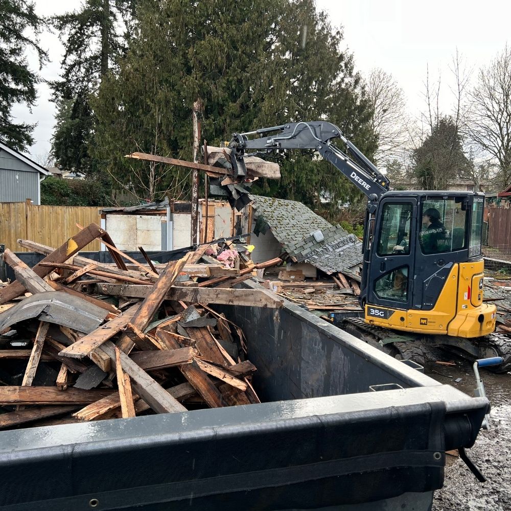 Mini excavator tearing down an RV home during a residential demolition project in Washington State
